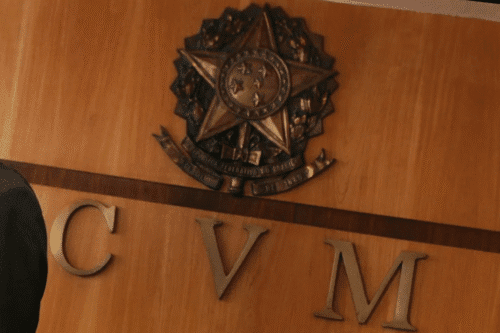 Imagem da parede com escudo de arma da polícia e as letras C, V, M abaixo, em uma sala de escritório ou delegacia.