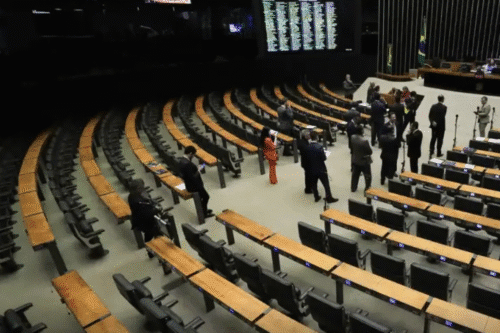 Imagem da Câmara dos Deputados durante uma sessão plenária, com deputados presentes discutindo e analisando propostas.
