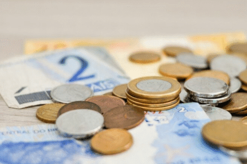 Imagem de moedas e notas de euro lado a lado, representando economia e dinheiro