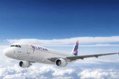 Um avião de passageiros com o logotipo da LATAM voa em um céu azul brilhante acima de nuvens brancas