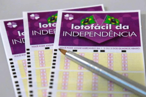 Imagem de uma aposta na Lotofácil da Independência, com duas cartelas de jogo e uma caneta dourada, destacando o tema de apostas e sorteios da loteria brasileira.