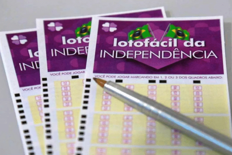 Imagem de uma aposta na Lotofácil da Independência, com duas cartelas de jogo e uma caneta dourada, destacando o tema de apostas e sorteios da loteria brasileira.