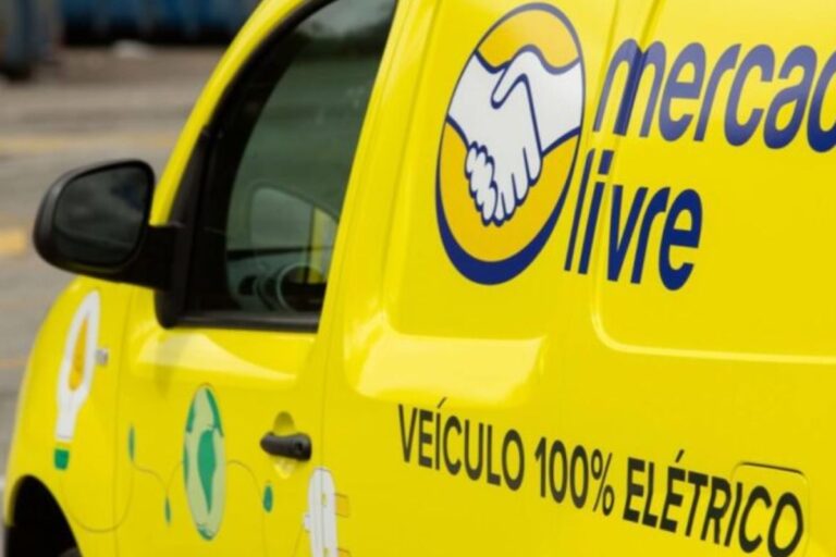 Veículo de entregas da Mercado Livre pintado de amarelo, destacando o logo de encontro de mãos e a descrição de veículo 100% elétrico, ideal para entregas sustentáveis.