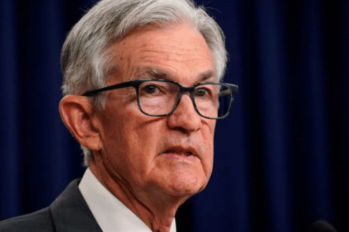 Foto de Powell na frente de uma cortina azul