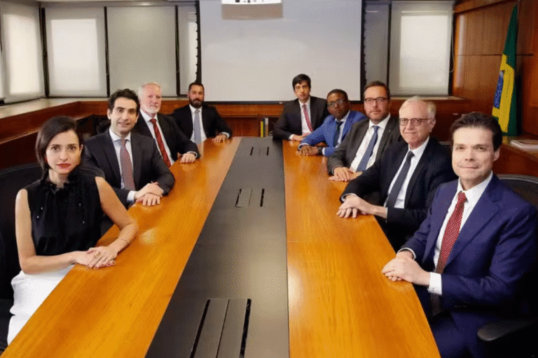 Integrantes do Copom reunidos em uma mesa de reunião, com bandeira do Brasil ao fundo.