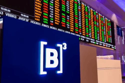 Imagem de uma tela de cotações de ações na bolsa de valores, com números em cores diferentes como verde, vermelho e amarelo, e o logo da B3 destacando-se na imagem.