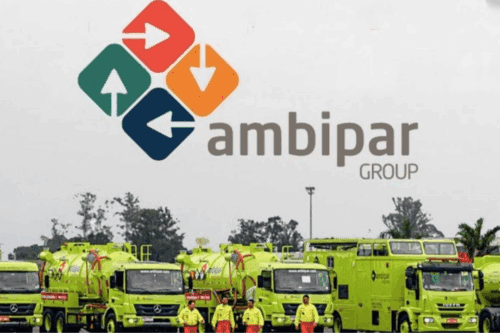 Imagem de frota de veículos de combate a incêndios em frente ao logo da Ambipar Group, empresa de gestão de resíduos e resposta a emergências,