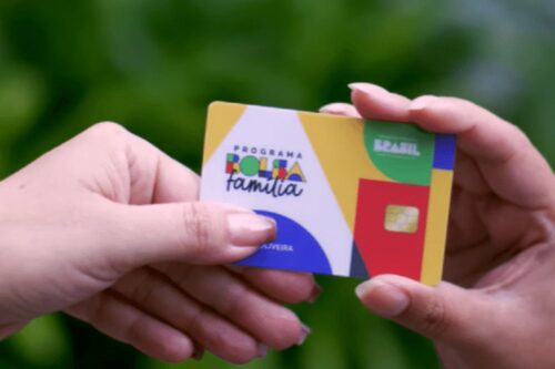Pessoa trocando cartão do Programa Família, iniciativa social que promove inclusão e educação no Brasil com foco em comunidades vulneráveis.