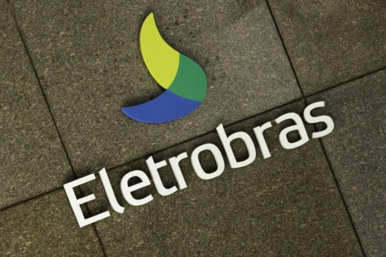 Logotipo da Eletrobras, companhia brasileira de energia, exibido no chão com letras brancas e símbolo de cores verdes e azuis, representando energia e sustentabilidade.