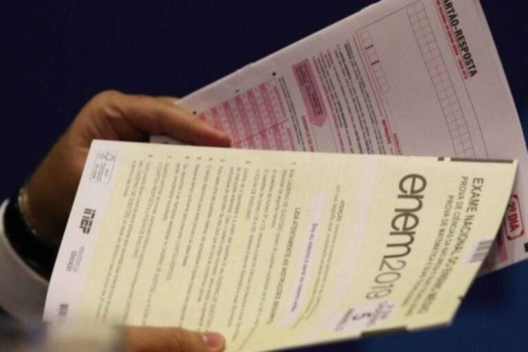 Pessoa segurando uma prova de exame nacional do ensino médio (ENEM)