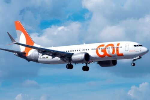 Avião da GOL Linhas Aéreas em voo sob céu parcialmente nublado, com logotipo destacado na fuselagem, representando o transporte aéreo brasileiro.