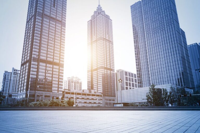 Vertiginosos arranha-céus em uma área urbana moderna ao pôr do sol, com destaque para edifícios de vidro