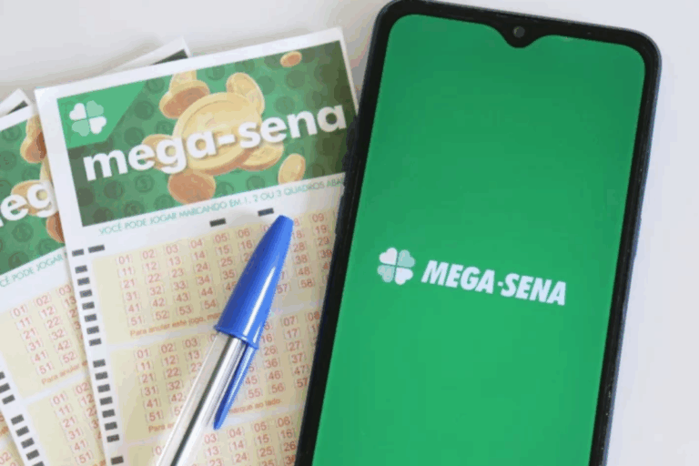 Imagem de uma tela de smartphone com o logo do Mega-Sena, acompanhada de bilhetes de loteria e uma caneta azul, representando apostas e jogos de azar.