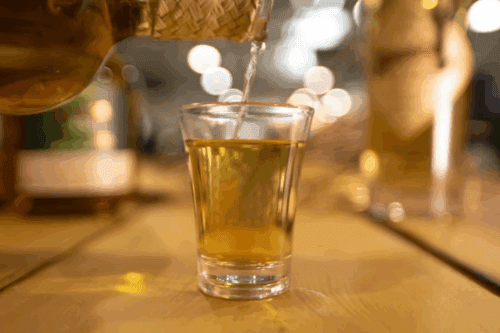 Imagem de um copo sendo preenchido com uma bebida dourada em um ambiente aconchegante, ideal para momentos de lazer e celebrações.