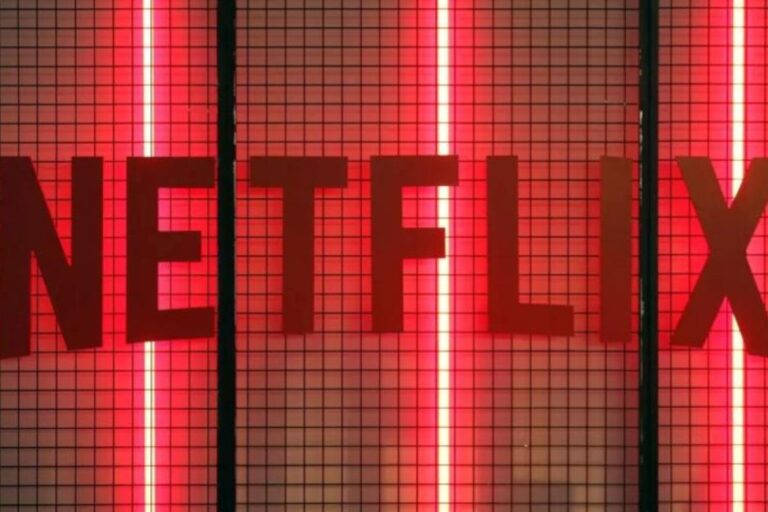 Imagem do logo da Netflix iluminado com luzes vermelhas e fundo de grade preta, representando o streaming de filmes e séries.