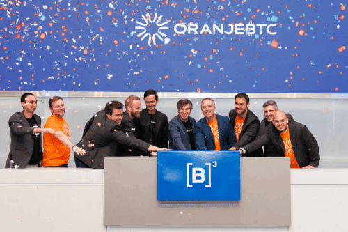 Equipe de profissionais celebrando na cerimônia de inauguração do OranjBTC na B3