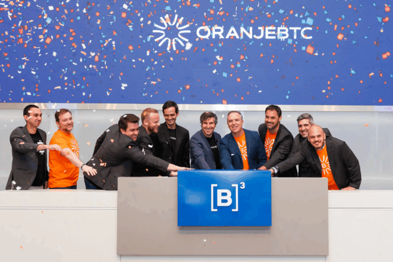 Equipe de profissionais celebrando na cerimônia de inauguração do OranjBTC na B3