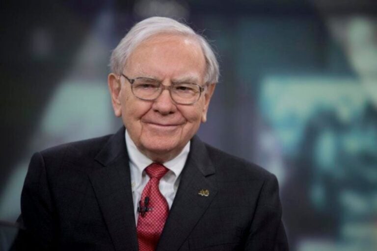 Imagem de Warren Buffet, sorrindo, com cabelo branco, vestindo terno e gravata.