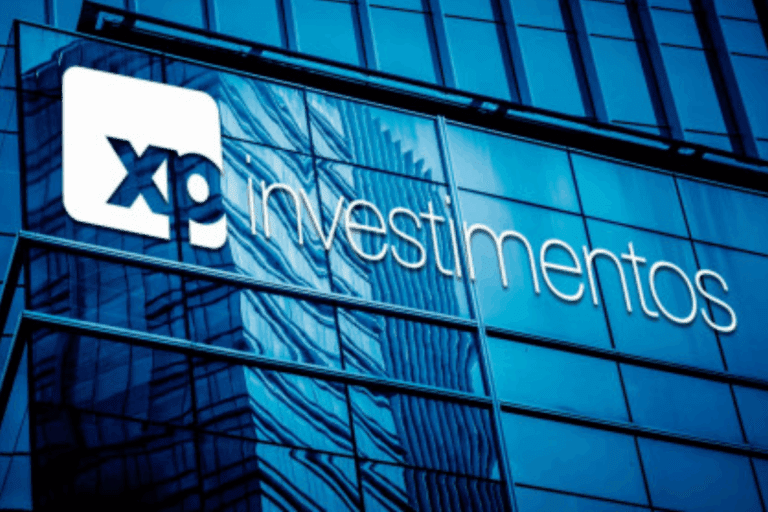 Edifício de vidro moderno com o logo da XP Investimentos e a palavra investimos escrita na fachada