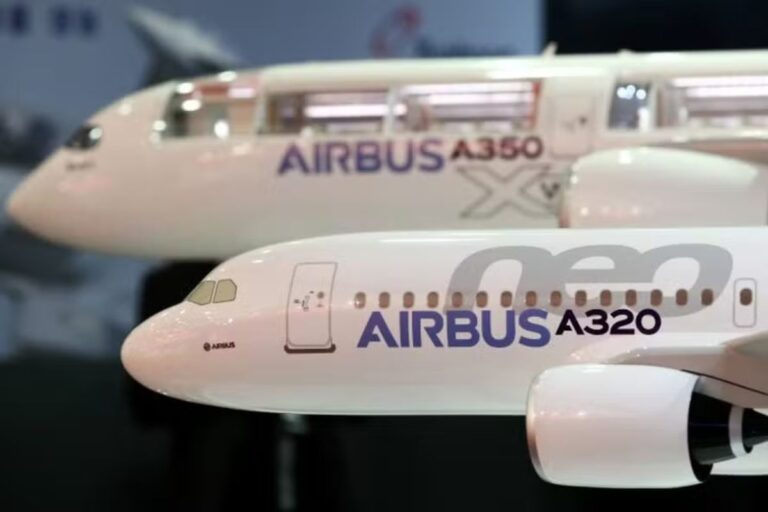 Close-up de dois modelos de aeronaves Airbus em miniatura. O modelo em primeiro plano, mais nítido, é o Airbus A320neo, com a fuselagem branca exibindo a inscrição "AIRBUS A320neo" em roxo e cinza.