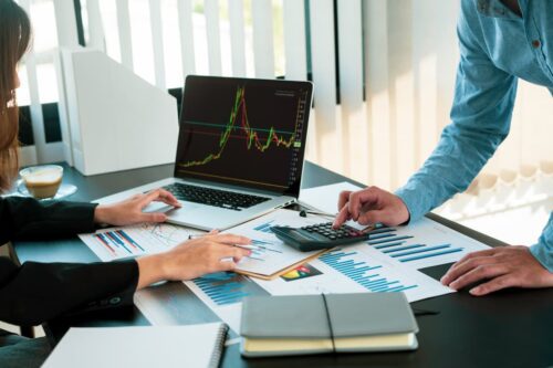 Profissionais analisando gráficos e relatórios financeiros sobre empresas que mais pagaram dividendos em 2025