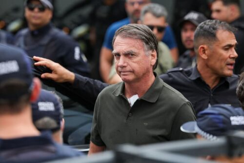 Jair Bolsonaro cercado por agentes de segurança em meio a apoiadores durante discussões sobre o PL da Dosimetria.